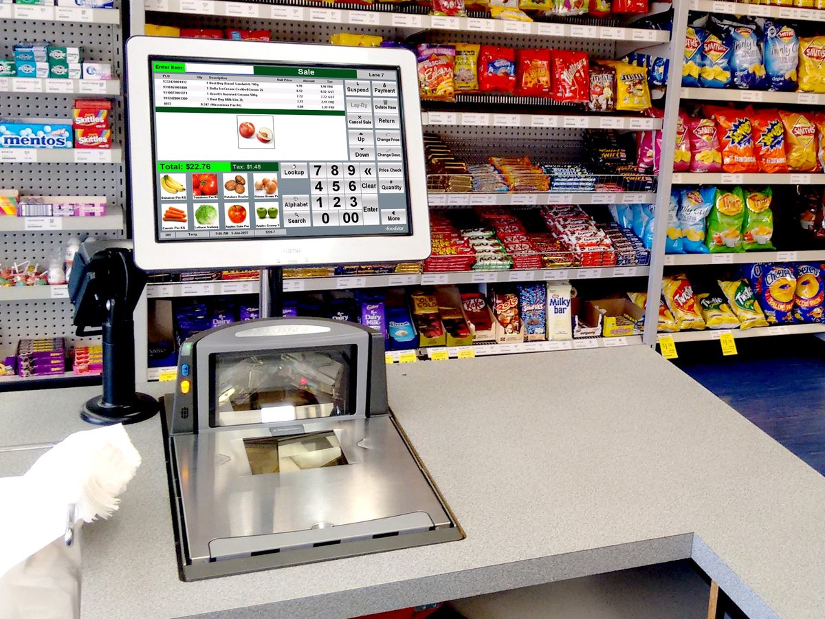 A point of sale touchscreen and barcode scanner at the counter of a convenience store